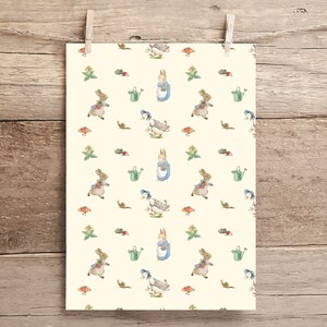 May include: A white background with a repeating pattern of Peter Rabbit and a duck. Peter Rabbit is wearing a blue dress and carrying a watering can. The duck is wearing a blue hat and carrying a watering can. There are also small green leaves, red radishes, and brown mushrooms in the pattern.