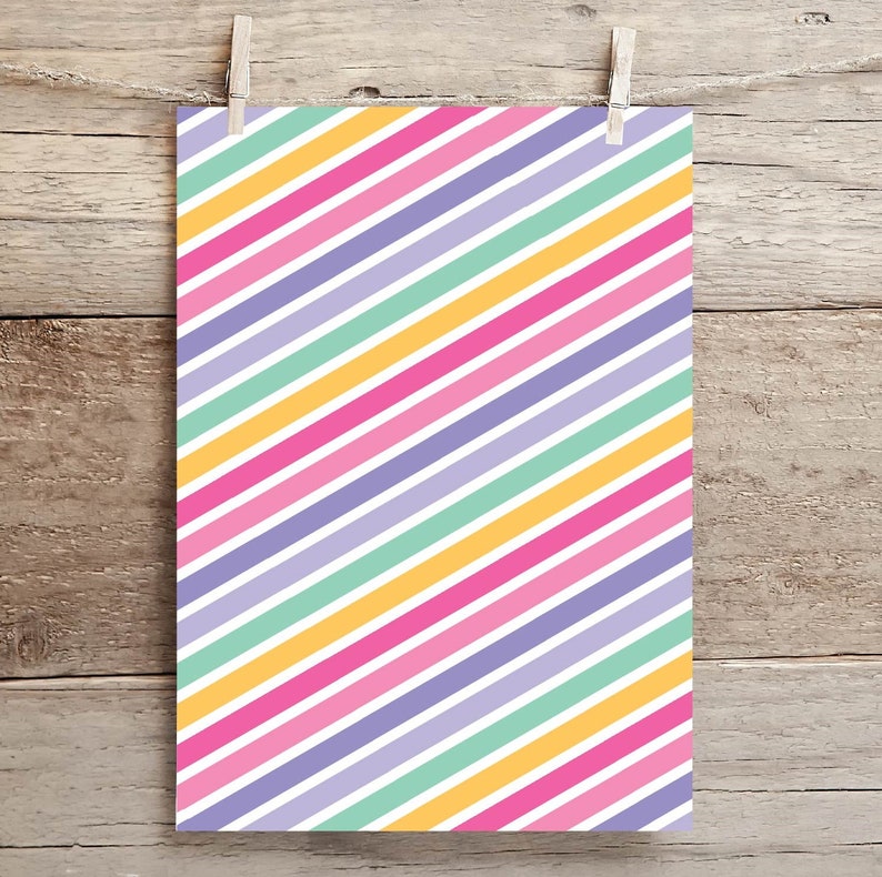 May include: A sheet of white paper with diagonal stripes in yellow, pink, light green, and purple.