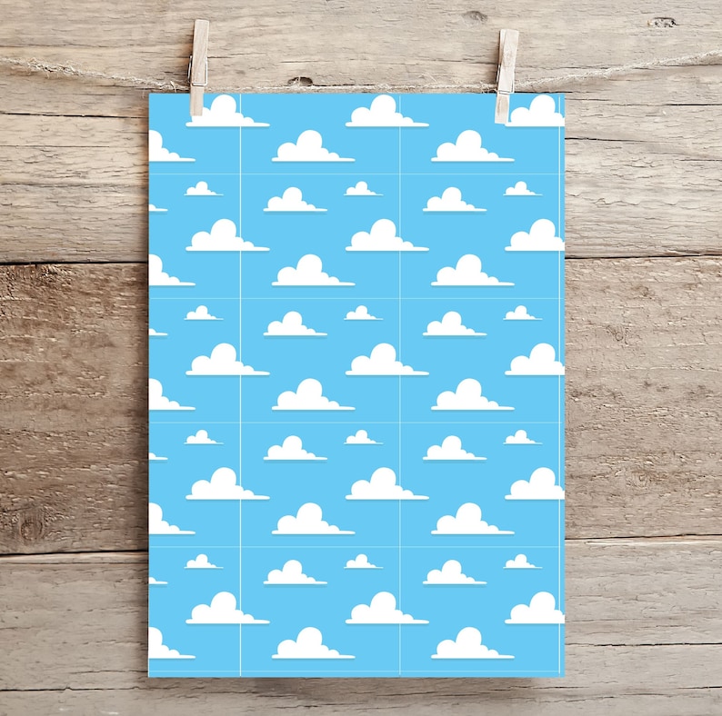 May include: A blue and white cloud pattern print, reminiscent of a cartoon sky. The design features white fluffy clouds scattered across a light blue background. The print is displayed on a rectangular piece of paper, held by a wooden clothespin.
