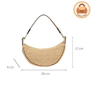 May include: A crescent-shaped rattan bag with a black handle and brown trim. The bag is beige and measures 28 cm long, 17 cm high, and 6 cm wide. The bag has a zipper closure. The bag has a logo that says "Rattan Bag".