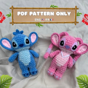 Pode incluir: Dois brinquedos de pelúcia de crochê, um azul e outro rosa, que se assemelham aos personagens Stitch e Angel do filme da Disney Lilo & Stitch. Os brinquedos são feitos com um fio texturizado e têm características faciais bordadas. A imagem inclui o texto "PDF PATTERN ONLY ENG / FR".