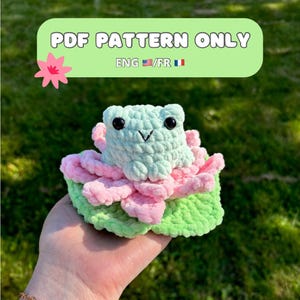 Puede incluir: Un patrón de crochet para una rana sentada en una flor de loto rosa y verde. El patrón está disponible en inglés y francés. Patrón PDF solamente. ENG/FR