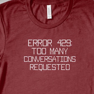 May include: Red t-shirt with white text that reads "ERROR 429: TOO MANY CONVERSATIONS REQUESTED".