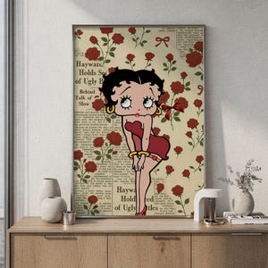 Könnte beinhalten: Ein rechteckiger Wandkunstdruck mit der Zeichentrickfigur Betty Boop in einem roten Kleid vor einem Hintergrund aus roten Rosen und Zeitungstext mit der Aufschrift Hayward Holds Secrets of Ugly Betty Behind Talk of Slow.