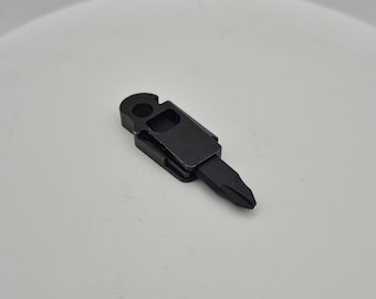May include: A small, black multi-tool with a flathead screwdriver tip. The tool has a key ring hole and a clip for attachment. The tool is made of metal and is designed for everyday carry.