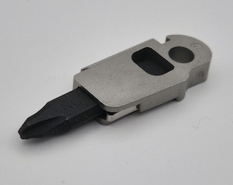 May include: A small, silver multi-tool with a black screwdriver tip. The tool has a bottle opener, a flathead screwdriver, and a Phillips head screwdriver.