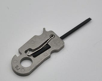 May include: A silver multi-tool with a black rubber strap and a small metal loop. The tool has a variety of functions, including a bottle opener, a pry bar, and a wire stripper. The tool is marked with the number "5J".