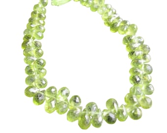 May include: A strand of faceted peridot gemstone beads. The beads are a light, translucent green color and are teardrop-shaped. The beads are strung together, forming a necklace or bracelet.