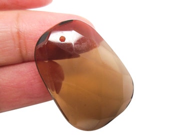 May include: A large, faceted, brown smoky quartz pendant with a hole drilled through the top for stringing.
