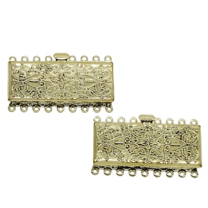 May include: Two gold-toned metal clasps with intricate filigree designs and multiple loops for attaching jewelry.