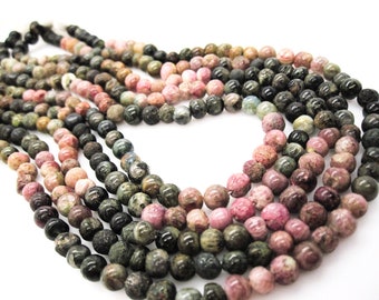 Peut inclure: Un brin de perles rondes multicolores. Les perles sont un mélange de rose, de vert et de noir. Les perles sont en pierre naturelle.