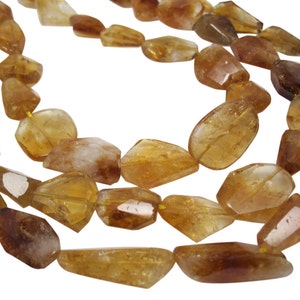 May include: A strand of faceted, golden brown citrine beads. The beads are irregular in shape and have a translucent appearance.