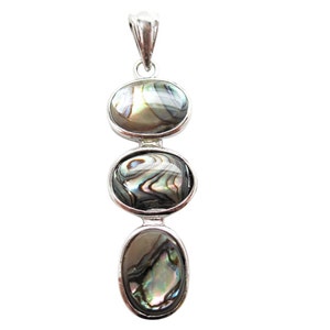 Pode incluir: Um pendente de prata com tr&ecirc;s pedras ovais de concha de abalone. As pedras iridescentes est&atilde;o dispostas verticalmente, cada uma emoldurada por uma moldura de prata. O pendente tem um design simples e elegante, adequado para uso di&aacute;rio.