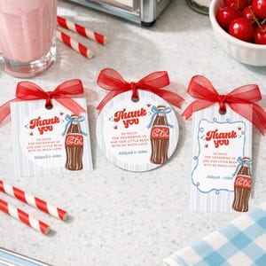 May include: Three gift tags with red bows, featuring a vintage Coca-Cola bottle illustration and the words "Thank You." The tags have the text "So much for showering us and our little bean with so much love" and the names "Abigail & John."