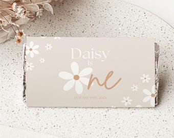 Op de afbeelding: Een lichtbruine kaart met witte madeliefjes en de tekst "Daisy is one" in bruin handschrift. De datum "January 15th, 2023" staat onder de tekst gedrukt.