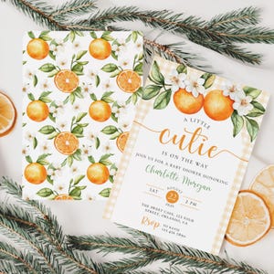 Peut inclure: Faire-part de baby shower avec des oranges &agrave; l'aquarelle, des fleurs et des feuilles vertes. Une invitation pr&eacute;sente un motif d'oranges r&eacute;p&eacute;t&eacute;es, l'autre le texte "A little cutie is on the way" et les d&eacute;tails de l'&eacute;v&eacute;nement. Le design comprend une bordure vichy.