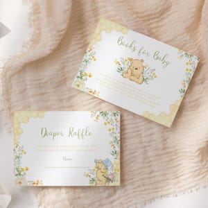 May include: Two baby shower cards with floral and Winnie the Pooh illustrations. One card reads "Books for Baby" and the other says "Diaper Raffle". Both cards have a honeycomb design and are decorated with flowers.