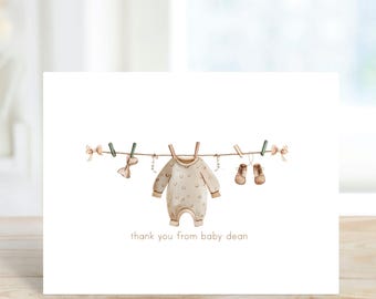 May include: A thank you card with a watercolor illustration of a baby onesie and shoes hanging on a clothesline. The text "thank you from baby dean" is printed below the illustration.