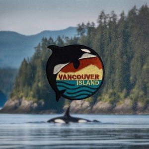 May include: An embroidered patch featuring a black and white orca whale leaping from the water, with a sunset behind it. The patch reads "Vancouver Island" in a vintage font.