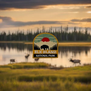 May include: An embroidered patch in yellow and green with a red sun, a white cloud, a silhouette of a bison, and the text "Elk Island National Park".