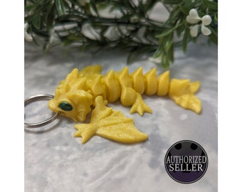 Ready to ship, assorted colours of wyvern keychain fidget toy made using articulated 3d printed Cinderwing3d design