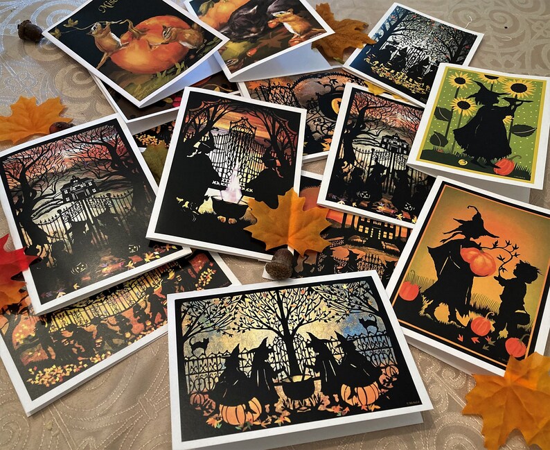 May include: A collection of Halloween-themed greeting cards featuring black silhouettes of witches, cats, and pumpkins against colorful backgrounds. The cards are perfect for sending spooky greetings to friends and family.