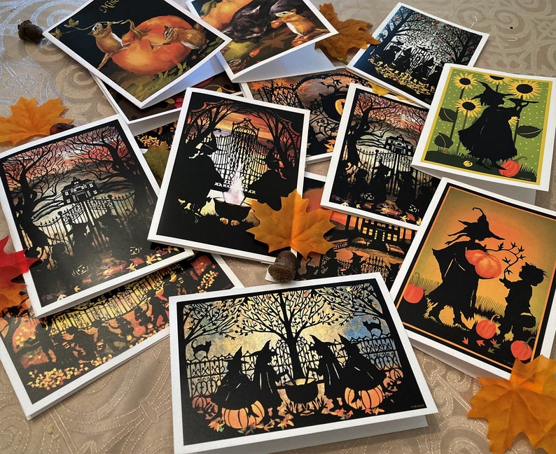 May include: A collection of Halloween greeting cards featuring various spooky silhouettes, including witches, cats, and pumpkins. The cards are decorated with autumnal colors and have a vintage aesthetic.