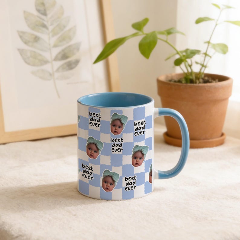 May include: A ceramic mug with a blue interior and handle. The exterior features a blue and white checkered pattern with baby photos and the text "best dad ever". A thoughtful gift for Father's Day or any special occasion.