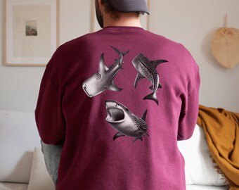 Puede incluir: Una sudadera color burdeos con un estampado gráfico de tres tiburones ballena en la espalda. Los tiburones están en blanco y negro y nadan en diferentes direcciones.