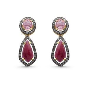 May include: A pair of gold-toned drop earrings. Each earring features a round, light pink gemstone surrounded by small, clear stones. Below, a teardrop-shaped, faceted, deep red gemstone is framed by a border of small, clear stones.