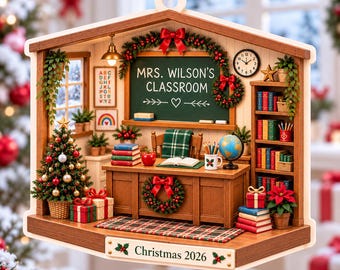 Puede incluir: Un adorno de aula en miniatura con un escritorio de madera, una pizarra con el texto MRS. WILSON'S CLASSROOM, un árbol de Navidad, estanterías y un letrero en la base que dice Christmas 2026. Incluye coronas festivas, libros y un globo.