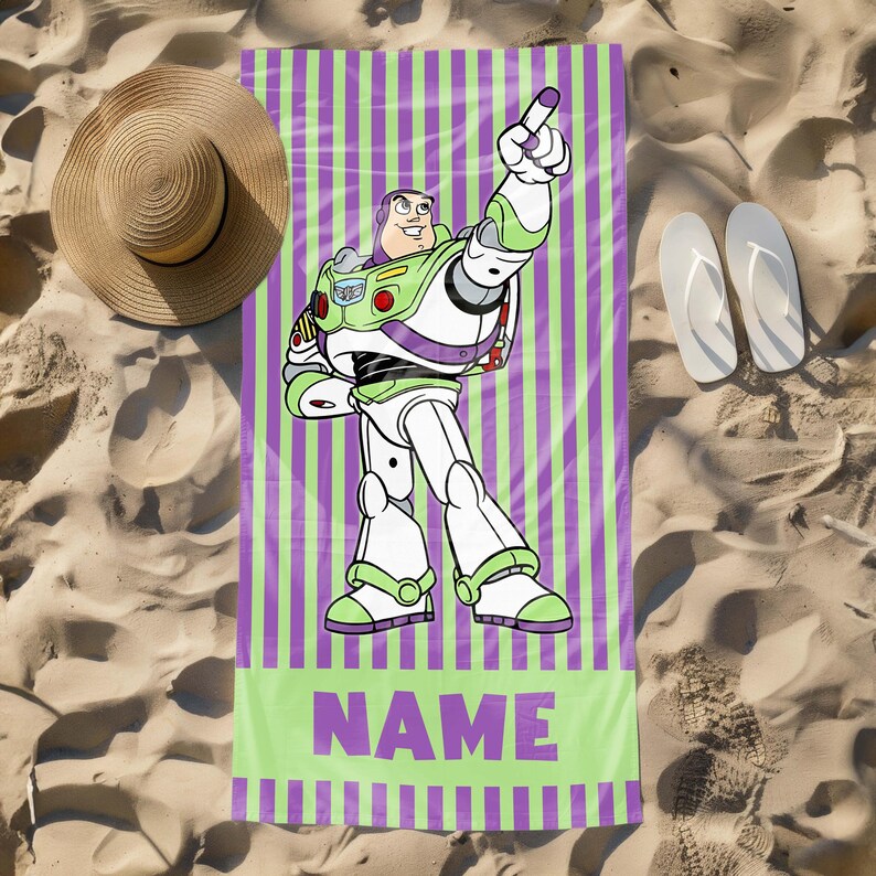 May include: A green and purple striped beach towel with a cartoon image of Buzz Lightyear from Toy Story. The towel has the word "NAME" printed in purple letters.