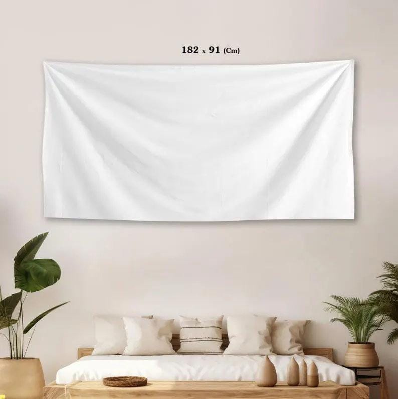 a large white canvas hanging on a wall above a bed with white pillows and a wooden headboard.
