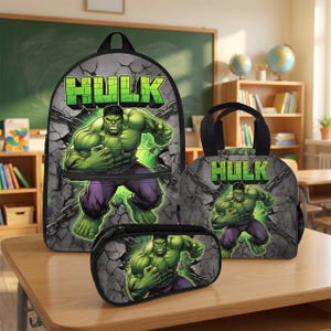 May include: A backpack, a lunch bag, and a pencil case set featuring the green Hulk character. Each item displays the word HULK in green block letters against a gray cracked concrete background with black chains. The items are arranged on a desk.