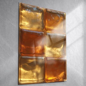 Może przedstawiać: Prostokątne dzieło sztuki ściennej z sześcioma kwadratowymi szklanymi blokami. Szklane bloki mają teksturowaną powierzchnię i są w odcieniach bursztynu, złota i brązu. Grafika jest zamontowana na ścianie w neutralnym kolorze, z widocznymi cieniami z okna.