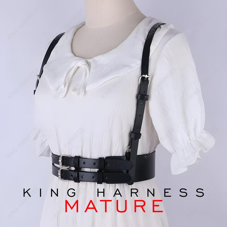 May include: Black leather harness with silver-tone buckles and straps. The harness features a double-belt design around the waist and shoulder straps. The text "KING HARNESS MATURE" is printed at the bottom of the image.