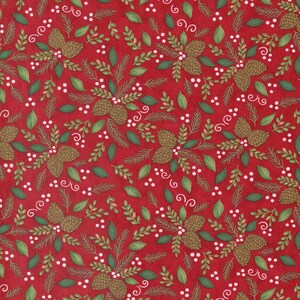 Op de afbeelding: Een rode stof met een herhalend patroon van bruine dennenappels, groene dennennaalden en kleine witte bessen. Het ontwerp bevat delicate witte, krullende lijnaccenten die verspreid zijn over de gehele botanische print.