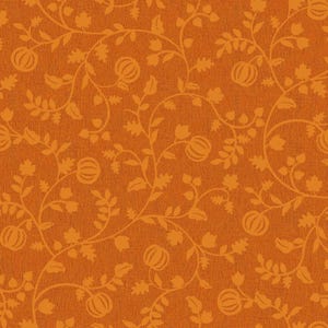 Op de afbeelding: Een gestructureerde stof met een herhalend patroon van oranje pompoensilhouetten en kronkelende wijnrankmotieven met bladeren tegen een donkerdere oranje achtergrond. Het ontwerp creëert een doorlopende botanische print over het oppervlak.
