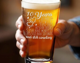 May include: A clear glass beer stein with a 10th anniversary message etched on the side. The message reads "10 Years 120 Months 521 Weeks 3,652 Days 87,648 Hours 5,258,880 Minutes 315,532,800 Seconds and still counting".