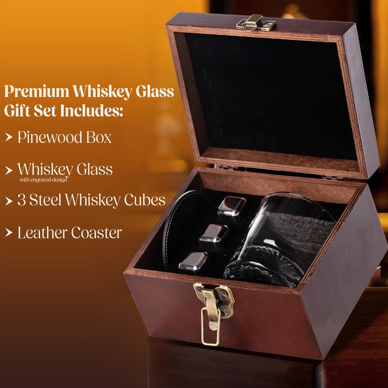 May include: A wooden gift box set with a whiskey glass, steel whiskey cubes, and a leather coaster. The box is open, revealing the contents. The text on the image reads "Premium Whiskey Glass Gift Set Includes: Pinewood Box, Whiskey Glass, 3 Steel Whiskey Cubes, Leather Coaster."