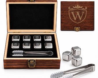 May include: A set of eight square stainless steel ice cubes, each engraved with a letter W inside a crest, housed in a dark wood box with a metal latch. The set includes a pair of metal tongs with white silicone tips for handling the cubes.