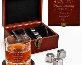 May include: A dark wooden gift box with a metal latch, engraved with 40th Anniversary, Forty years down. Forever to go! and heart icons. Inside are two glass tumblers with matching engravings, three stainless steel ice cubes, and two coasters.