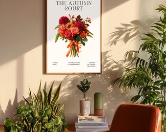 May include: A framed art print with the text "THE AUTUMN COURT" and a floral arrangement in shades of red, orange, and green. The print is displayed above a brown leather chair and potted plants.