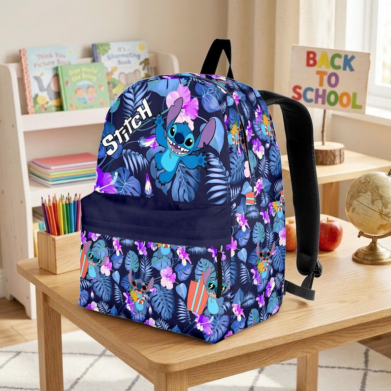 May include: A navy blue backpack featuring a Stitch character design. The backpack has a floral pattern with blue, purple, and white accents. The word "Stitch" is written in white. The backpack has black straps and a front pocket.