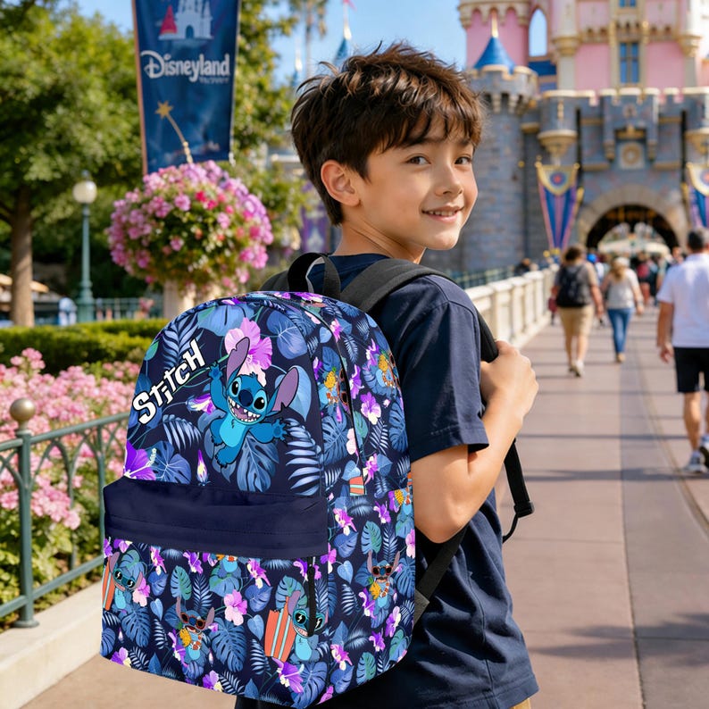 May include: A navy blue backpack featuring the character Stitch from Lilo & Stitch. The backpack has a dark blue front pocket and is covered in a pattern of blue, purple, and pink flowers and leaves. The word "Stitch" is written in white script.