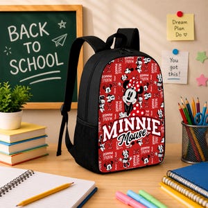 Pu&ograve; includere: Uno zaino nero con un pannello frontale rosso caratterizzato da un motivo ripetuto di Minnie Mouse e dalla scritta Minnie Mouse in bianco. Lo zaino &egrave; dotato di spallacci neri, una maniglia superiore e tasche laterali in rete.