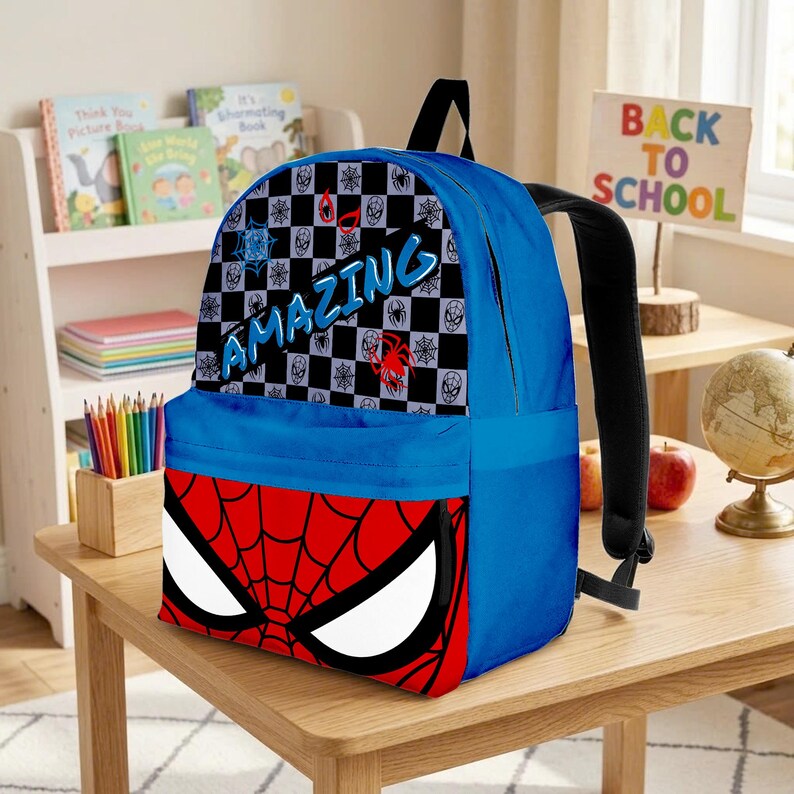 May include: Blue Spider-Man backpack with a red and black design. The backpack features the word "AMAZING" and a Spider-Man face on the front. The backpack has black straps and is sitting on a wooden table.