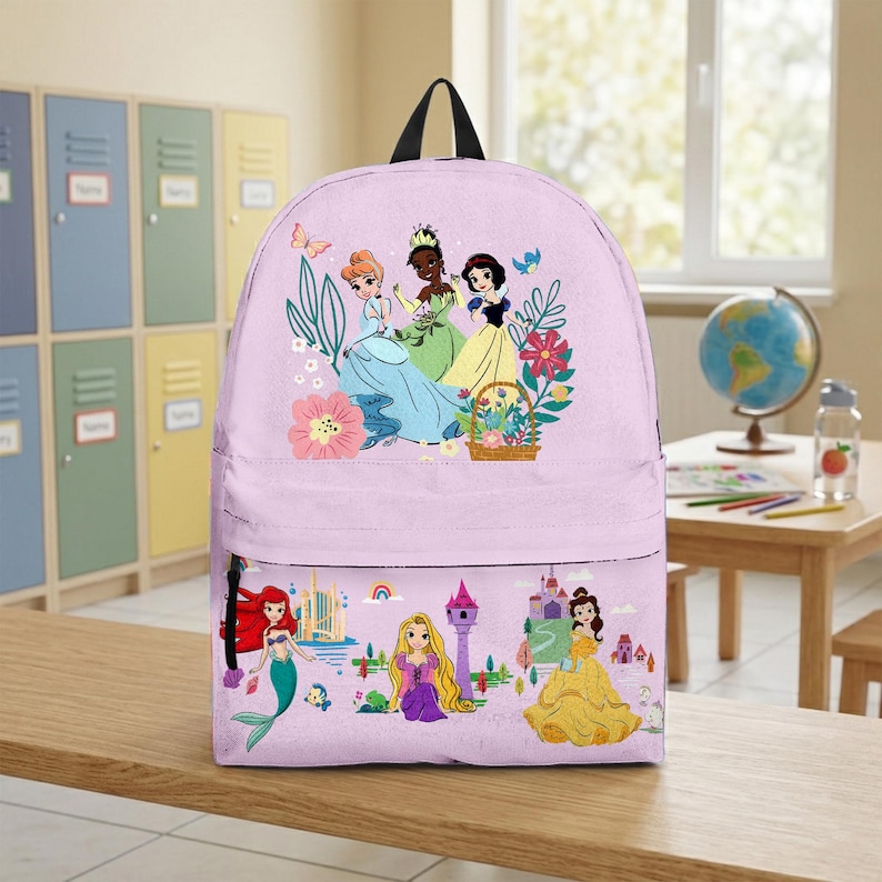 May include: A light purple backpack featuring a colorful illustration of animated princesses. The top section displays three princesses with flowers and a basket. The bottom section shows a mermaid, a princess with long hair, and a princess in a yellow dress.