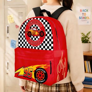 May include: Red backpack featuring Lightning McQueen from the Cars movie. The backpack has a large front pocket and a top handle. The design includes a checkered flag pattern, the number 95, and the words "Lightning McQueen".