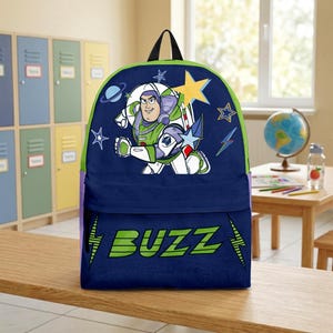 May include: A navy blue backpack featuring a graphic of the character Buzz Lightyear in a space suit, surrounded by yellow and blue stars, a planet, and lightning bolts. The word BUZZ is printed in large green letters on the front pocket.